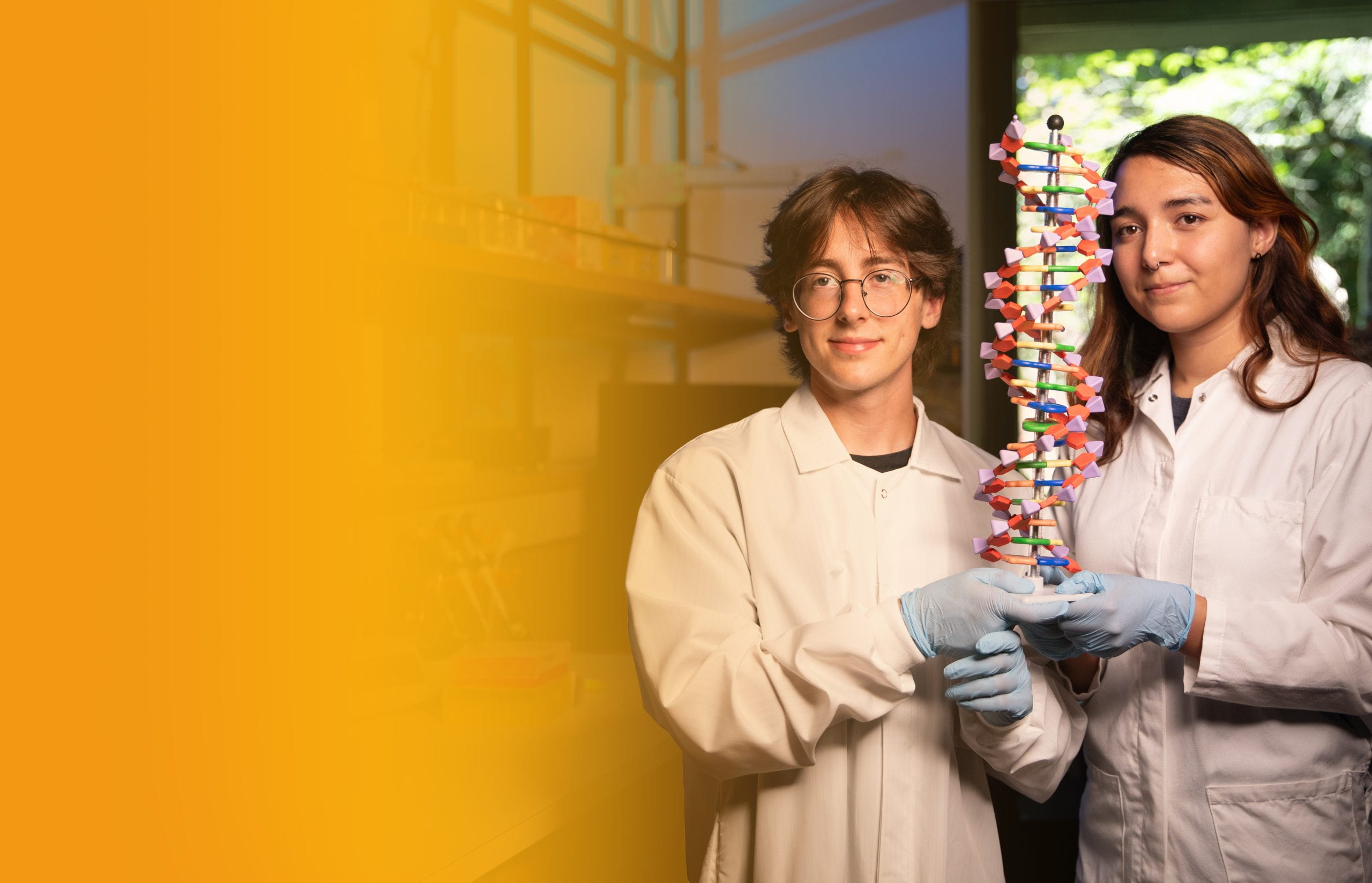 Two students in Russ Detig lab holding a model of DNA