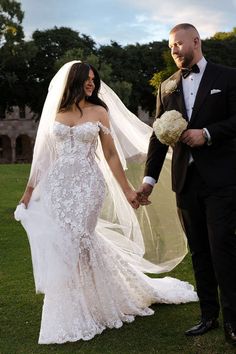 the bride and groom are holding hands