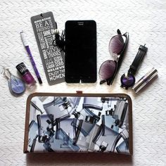 the contents of a purse sitting on top of a white table next to sunglasses and other items
