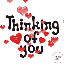a sign that says " thinking of you " with red hearts around it