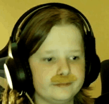 a close up of a person wearing headphones and making a funny face