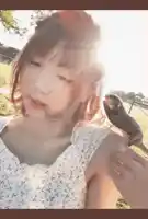 a woman holds a small bird on her shoulder